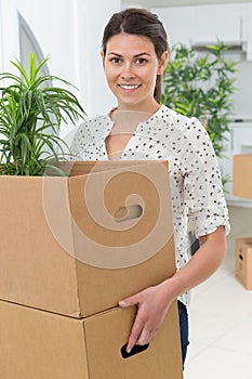 Woman carrying box and potted plant