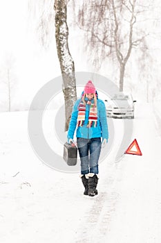 Woman carrying gas can snow car trouble