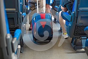 Woman carrying hand luggage suitcase in the cabin