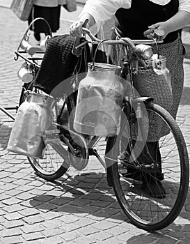 Woman carrying milk cans and black and white effect