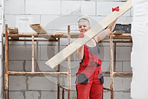 Woman carrying plank boards on construction site