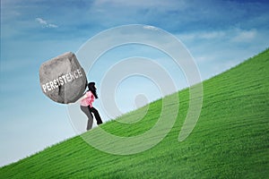 Woman carrying rock with persistence word