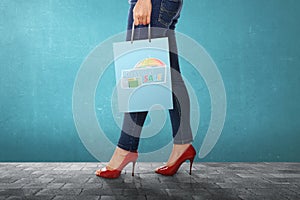 Woman carrying shopping bag with Monsoon sale sign