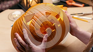 Woman carving Jack O Lantern pumpkin for Halloween