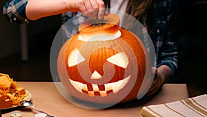 Woman carving Jack O Lantern pumpkin for Halloween