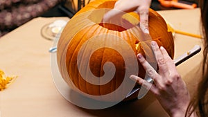 Woman carving Jack O Lantern pumpkin for Halloween