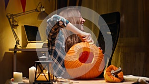 Woman carving Jack O Lantern pumpkin for Halloween