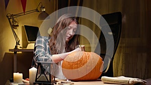 Woman carving Jack O Lantern pumpkin for Halloween