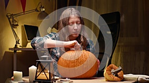 Woman carving Jack O Lantern pumpkin for Halloween