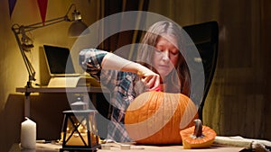 Woman carving Jack O Lantern pumpkin for Halloween