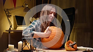 Woman carving Jack O Lantern pumpkin for Halloween