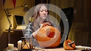 Woman carving Jack O Lantern pumpkin for Halloween