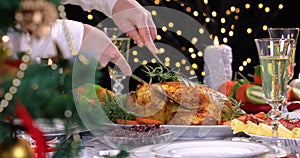 Woman carving roasted chicken on Christmas dinner