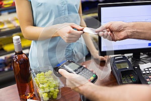 Woman at cash register paying with credit card