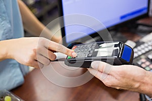 Woman at cash register paying with credit card