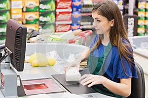 Woman cashier beeping an item