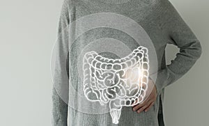 Woman in casual clothes suffering from indigestion pain, highlighted  visualisation of intestine photo