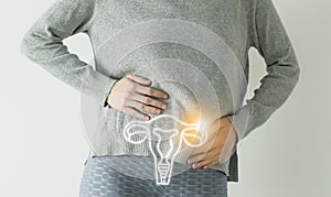 Woman in casual clothes suffering from indigestion pain, highlighted  visualisation of uterus photo