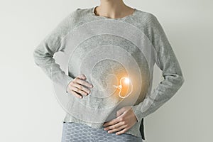 Woman in casual grey clothes suffering from indigestion pain, highlighted  visualisation of spleen photo