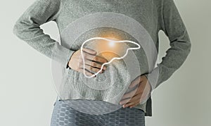 Woman in casual grey clothes suffering from indigestion pain, highlighted  visualisation of liver photo