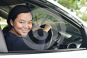 Woman in casual wear looking over her shoulder while drivi