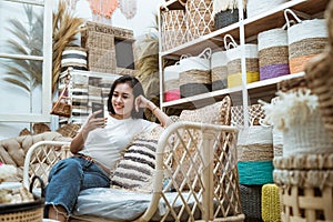 woman casually sitting on the sofa using a smartphone