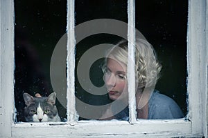 Woman and Cat Looking at the Rainy Weather By the Window