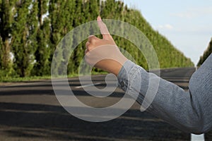 Woman catching car on road, closeup. Hitchhiking trip