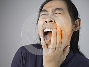 Woman catching on cheek because she have a toothache. Healthcare and medical concepts