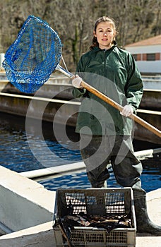 Woman catching sturgeon at pool