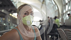 Woman caucasian at airport with wearing protective medical mask on head against the background of the plane. Coronavirus