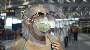 Woman caucasian at airport with wearing protective medical mask on head against the background of the plane. Coronavirus