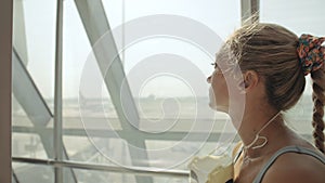 Woman caucasian at airport with wearing protective medical mask on head against the background of the plane. Coronavirus
