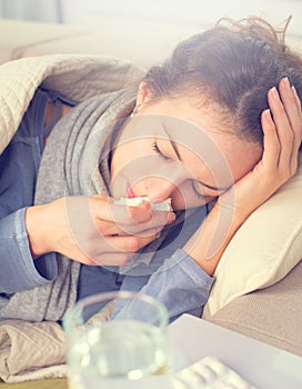 Woman caught cold. Sneezing into tissue