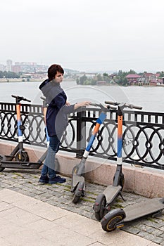 A woman cautiously inspects rental electric