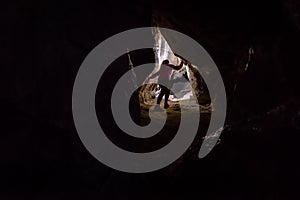 Woman caver spelunker exploring the cave photo