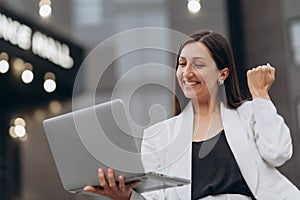 Woman celebrate with laptop.