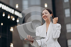 Woman celebrate with laptop.