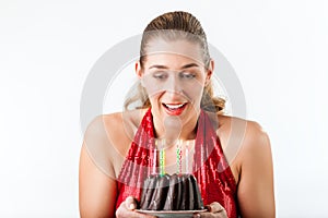 Woman celebrating birthday with cake and candles