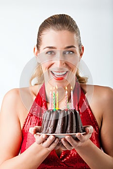 Woman celebrating birthday with cake and candles