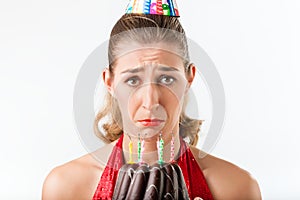 Woman celebrating birthday with cake candles wiped