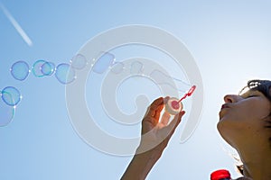 Woman celebrating blowing a stream of bubbles