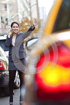 Woman on Cell Phone Hailing a Yellow Taxi Cab