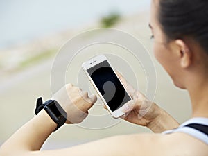 Woman with cellphone and fitness tracker photo