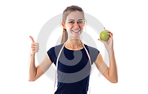 Woman with centimeter holding an apple and showing okay