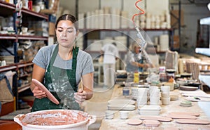 Woman ceramist painting crafted plates