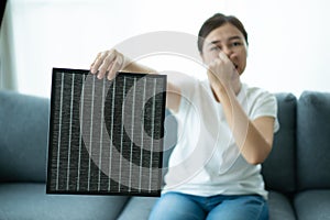 Woman changing air purifier filter.
