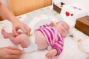 Woman changing the baby`s diaper