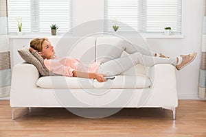 Woman Changing Channel With Remote Control