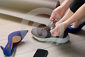 Woman changing high heels to sport running shoes. Exercise after office, healthy living concept